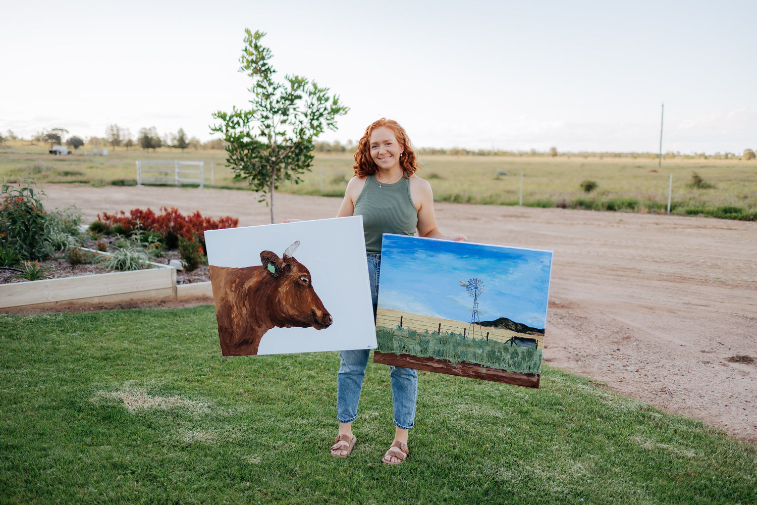 Julia Proud-Maher holding two artworks